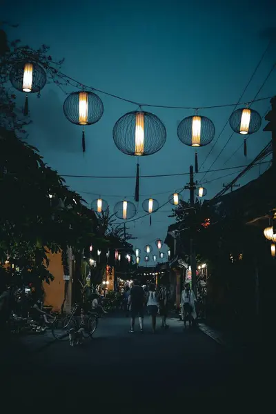 Hoi An, Vietnam 'daki gece caddesinde yayaların üzerinde yanan fenerler asılı, antik kentte büyülü bir atmosfer yaratıyor..