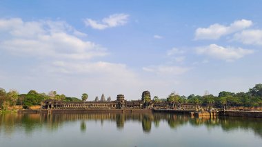 Angkor Wat tapınağının görüntüsü, Siem Reap, Kamboçya 'daki hendekten alınan mavi gökyüzünün altındaki suya yansıdı..