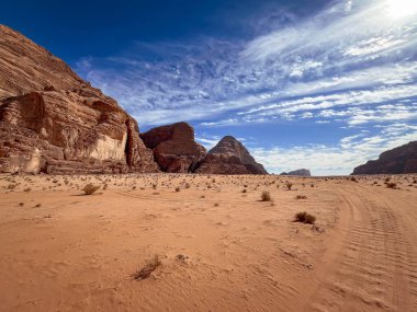 Ürdün, Wadi Rum 'da engin bir çöl manzarası dramatik kaya oluşumları ve bulutlu bir gökyüzü.