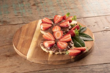 iki waffle çikolatalı ve fındık kremalı yuvarlak ahşap tahtada ahşap masa