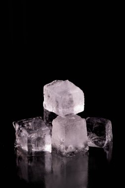 Siyah zemin üzerinde izole edilmiş devasa buz küpleri.