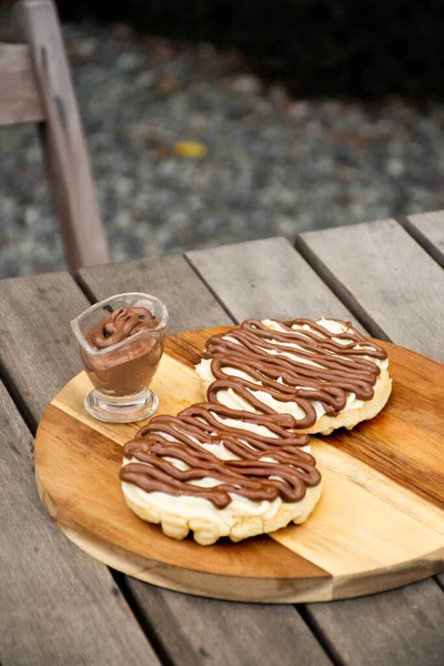 Fındıklı çikolatalı waffle ve bahçedeki ahşap masada beyaz çikolata.