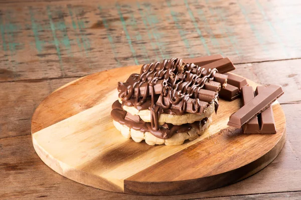 double waffle with chocolate coating on chocolate bars on rustic wooden table at an angle
