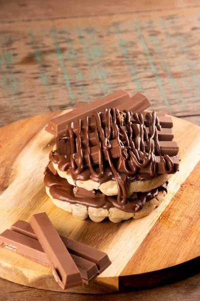 double waffle with chocolate coating on chocolate bars on rustic wooden table from above