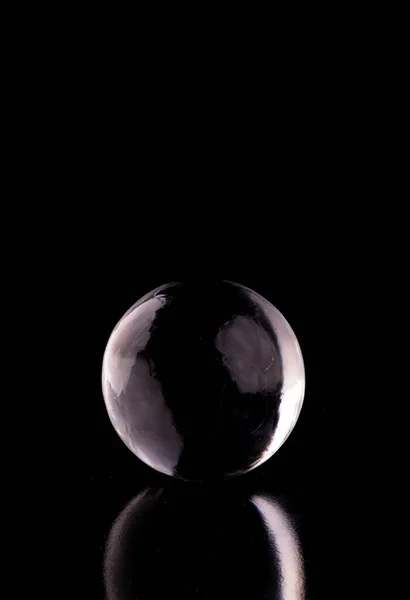 stock image crystalline translucent ice and crystal sphere isolated on black background with reflection from the front