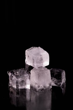 Siyah zemin üzerinde izole edilmiş devasa buz küpleri.