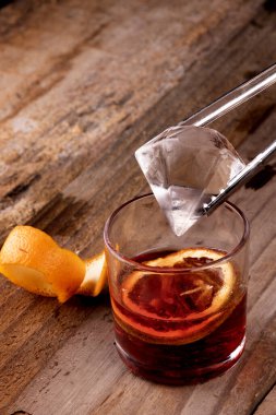 Elmas buzu kırmızı negroni 'ye koy Campari ve vermut ile portakallı ahşap masaya.