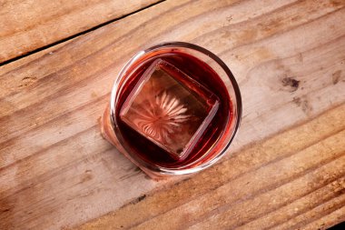 Kırmızı negroni campari. Profesyonel buzlu. Kırsal ahşap masa manzaralı.