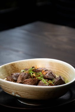 Kapalı arka planda ahşap masa üzerinde ızgara et ile doğu eriştesi tabağı