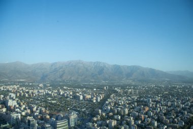 Santiago şehrinin panoramik manzarası Latin Amerika 'nın en yüksek binasından öğleden sonra gökyüzü Costaneira mavi gökyüzü ve arka planda dağlar