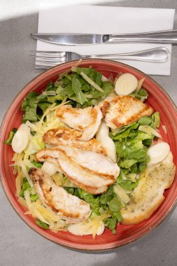 Salata tabağı ve sağlıklı ızgara tavuk göğsü. Restoranda. Gri masa manzaralı.