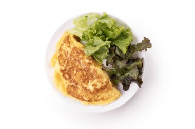 Yuvarlak beyaz tabakta omlet yeşil marul karışımı yapraklar beyaz arka plan görünümünde izole