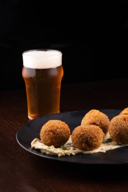 Kızarmış balık köftesi aperatif morina somonu yarım litre bira bulanık ve koyu arkaplan