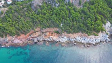 yeşil ağaçlar kayalar turkuaz deniz dronu görüntüsü