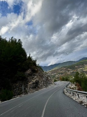 Dağlarda yol sonbahar ağaçlarını bulutlandırır.