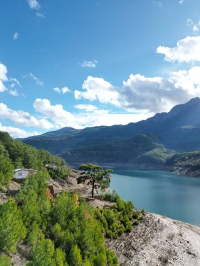 Dağlardaki göl... Kayalık kıyı ağaçları... 