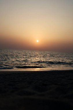 Günbatımı okyanus ufku, ufukta dağlar