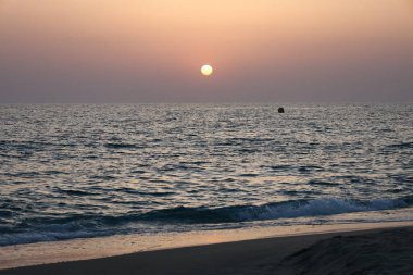 Günbatımı okyanus ufku, ufukta dağlar