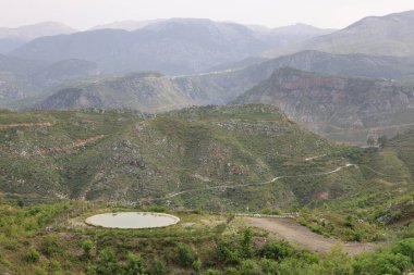 Dağlık peyzaj göleti. Dağlık viraj yolu. yukarıdan dağ manzarası