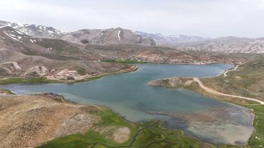 Dağ yeşili manzara. Ufuktaki ilk çimenlikte, karla kaplı dağları sersemleten doğa. Yüksek kalite fotoğraf