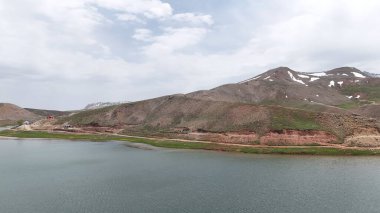 Dağ yeşili manzara. Ufuktaki ilk çimenlikte, karla kaplı dağları sersemleten doğa. Yüksek kalite fotoğraf