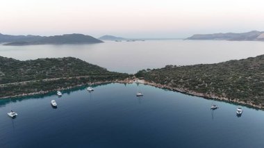 Kıyı dağı manzarası, deniz tatil yatları, altın saat.