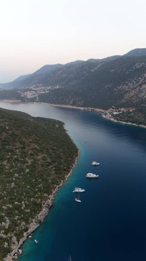 Kıyı dağı manzarası, deniz tatil yatları, altın saat.