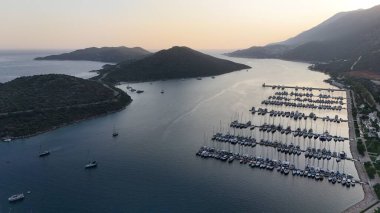 Kıyı dağı manzarası, deniz tatil yatları, altın saat.