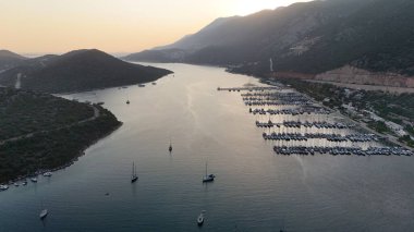 Kıyı dağı manzarası, deniz tatil yatları, altın saat.