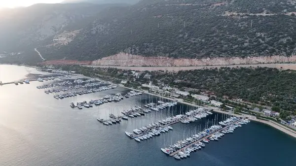 Kıyı dağı manzarası, deniz tatil yatları, altın saat.