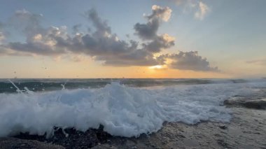 Gün batımında kıyı manzarası. Okyanus sahilinde gün batımı. Dalgalar, deniz köpüğü. Gün batımında Rocky Shore. - Evet. Yüksek kalite 4k görüntü