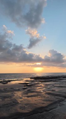 Gün batımında kıyı manzarası. Okyanus sahilinde gün batımı. Dalgalar, deniz köpüğü. Gün batımında Rocky Shore. - Evet. Yüksek kalite 4k görüntü