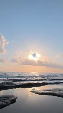 Gün batımında kıyı manzarası. Okyanus sahilinde gün batımı. Dalgalar, deniz köpüğü. Gün batımında Rocky Shore. - Evet. Yüksek kalite 4k görüntü