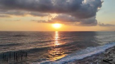 Gün batımında kıyı manzarası. Okyanus sahilinde gün batımı. Dalgalar, deniz köpüğü. Gün batımında Rocky Shore. - Evet. Yüksek kalite 4k görüntü