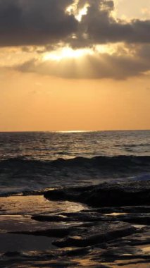 Gün batımında kıyı manzarası. Okyanus sahilinde gün batımı. Dalgalar, deniz köpüğü. Gün batımında Rocky Shore. - Evet. Yüksek kalite 4k görüntü