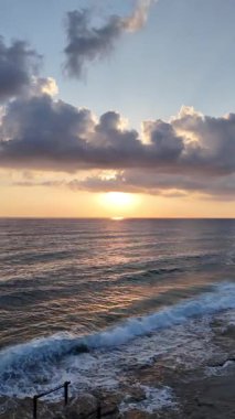 Gün batımında kıyı manzarası. Okyanus sahilinde gün batımı. Dalgalar, deniz köpüğü. Gün batımında Rocky Shore. - Evet. Yüksek kalite 4k görüntü