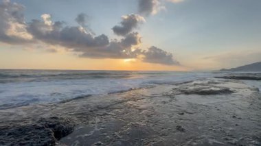 Gün batımında kıyı manzarası. Okyanus sahilinde gün batımı. Dalgalar, deniz köpüğü. Gün batımında Rocky Shore. - Evet. Yüksek kalite 4k görüntü