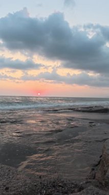 Gün batımında kıyı manzarası. Okyanus sahilinde gün batımı. Dalgalar, deniz köpüğü. Gün batımında Rocky Shore. - Evet. Yüksek kalite 4k görüntü