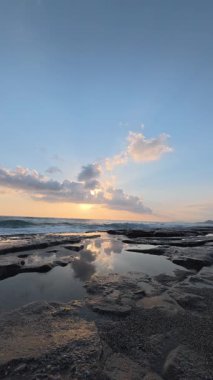 Gün batımında kıyı manzarası. Okyanus sahilinde gün batımı. Dalgalar, deniz köpüğü. Gün batımında Rocky Shore. - Evet. Yüksek kalite 4k görüntü