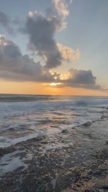 Gün batımında kıyı manzarası. Okyanus sahilinde gün batımı. Dalgalar, deniz köpüğü. Gün batımında Rocky Shore. - Evet. Yüksek kalite 4k görüntü
