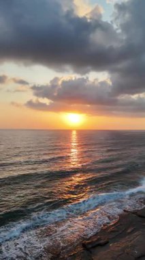 Gün batımında kıyı manzarası. Okyanus sahilinde gün batımı. Dalgalar, deniz köpüğü. Gün batımında Rocky Shore. - Evet. Yüksek kalite 4k görüntü