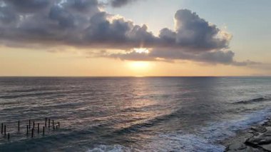 Gün batımında kıyı manzarası. Okyanus sahilinde gün batımı. Dalgalar, deniz köpüğü. Gün batımında Rocky Shore. - Evet. Yüksek kalite 4k görüntü