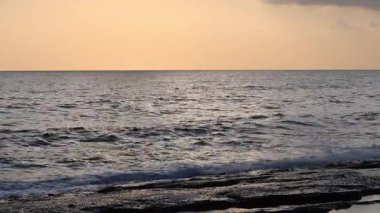 Gün batımında kıyı manzarası. Okyanus sahilinde gün batımı. Dalgalar, deniz köpüğü. Gün batımında Rocky Shore. - Evet. Yüksek kalite 4k görüntü