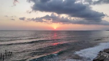 Gün batımında kıyı manzarası. Okyanus sahilinde gün batımı. Dalgalar, deniz köpüğü. Gün batımında Rocky Shore. - Evet. Yüksek kalite 4k görüntü