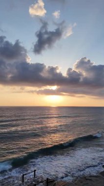 Gün batımında kıyı manzarası. Okyanus sahilinde gün batımı. Dalgalar, deniz köpüğü. Gün batımında Rocky Shore. - Evet. Yüksek kalite 4k görüntü