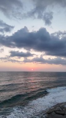 Gün batımında kıyı manzarası. Okyanus sahilinde gün batımı. Dalgalar, deniz köpüğü. Gün batımında Rocky Shore. - Evet. Yüksek kalite 4k görüntü