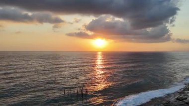 Gün batımında kıyı manzarası. Okyanus sahilinde gün batımı. Dalgalar, deniz köpüğü. Gün batımında Rocky Shore. - Evet. Yüksek kalite 4k görüntü
