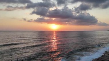 Gün batımında kıyı manzarası. Okyanus sahilinde gün batımı. Dalgalar, deniz köpüğü. Gün batımında Rocky Shore. - Evet. Yüksek kalite 4k görüntü