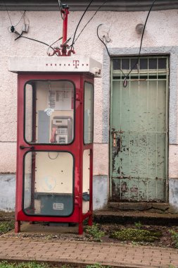 Küçük bir Balkan köyünün caddesinde eski bir telefon.