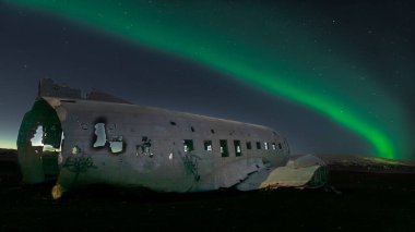 Romantik bir Aurora Borealis 'i olan terk edilmiş eski bir uçağın güzel bir fotoğrafı.
